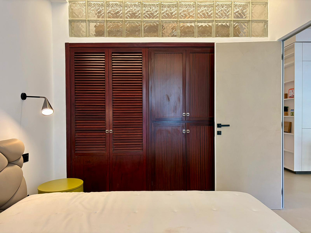 Camera da letto con armadio a muro in legno e vetrocemento