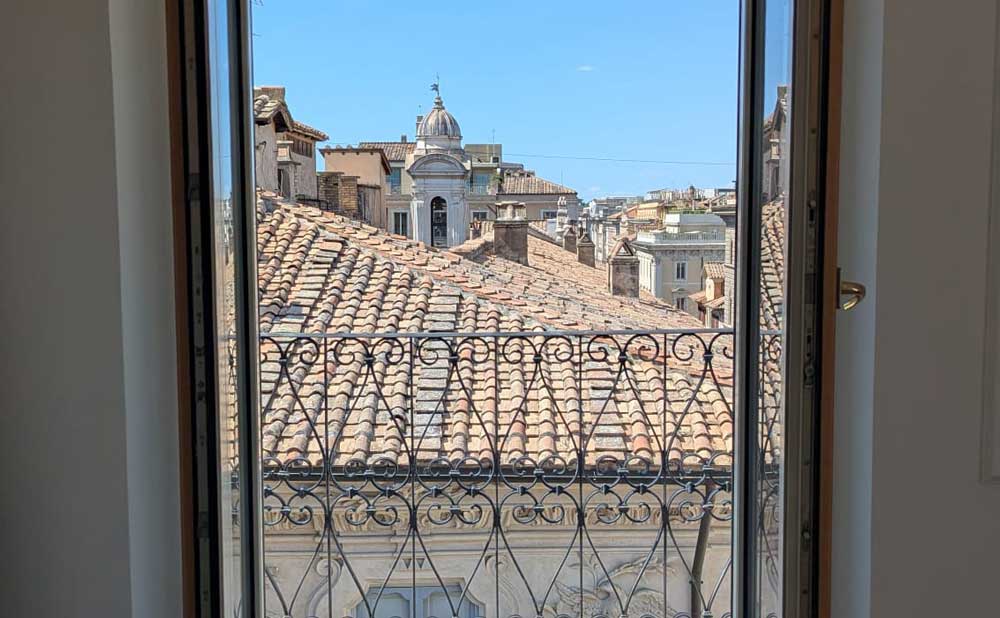 Portafinestra con ringhiera in ferro battuto affacciata sui tetti del centro storico